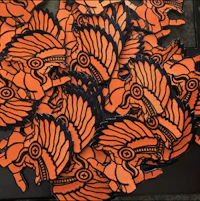 a pile of orange and black pins on a table